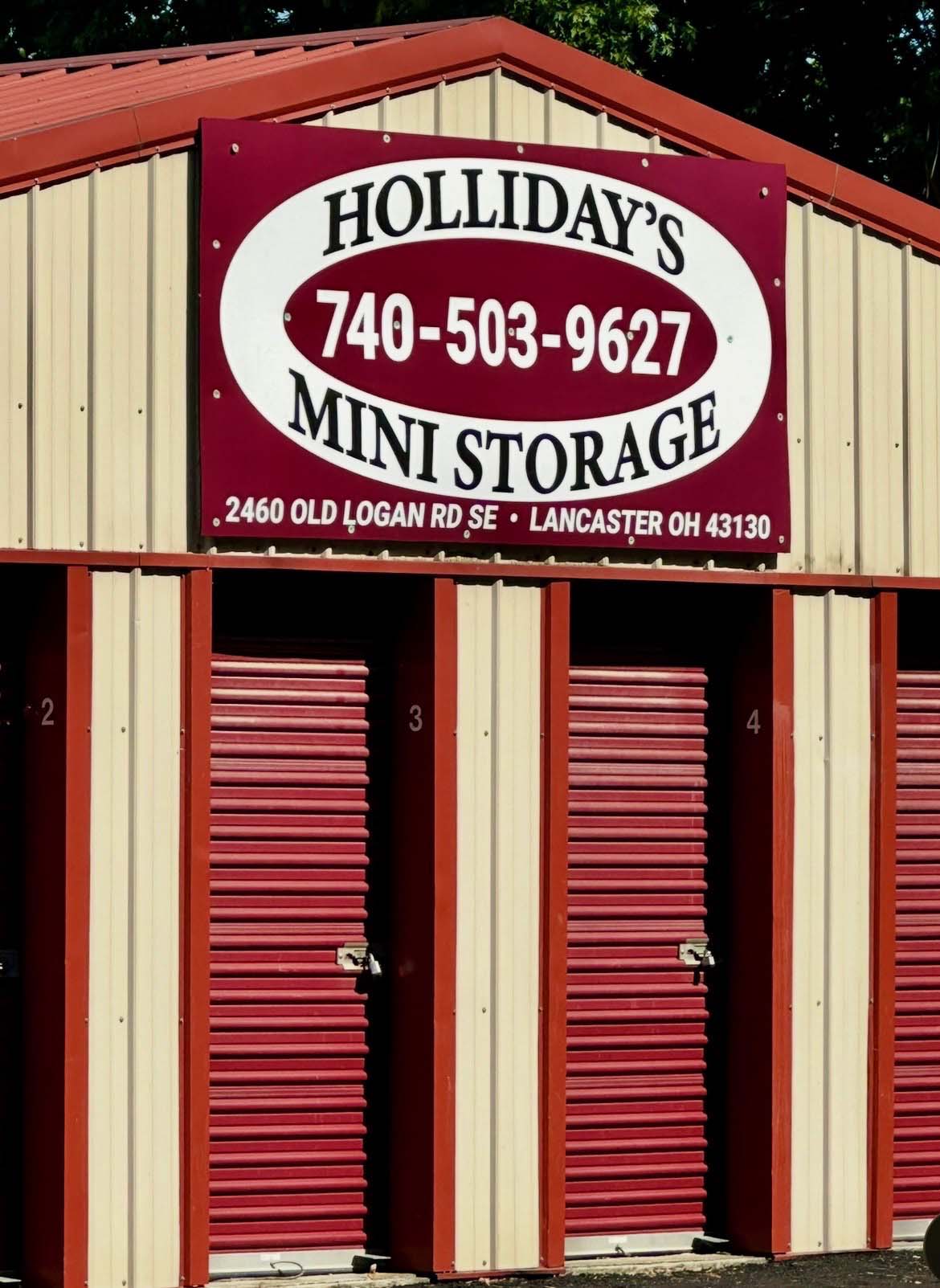 Roadside Holliday's Mini Storage sign with phone number 740-503-9627, easy to spot driving down Old Logan Road in Lancaster, Ohio.