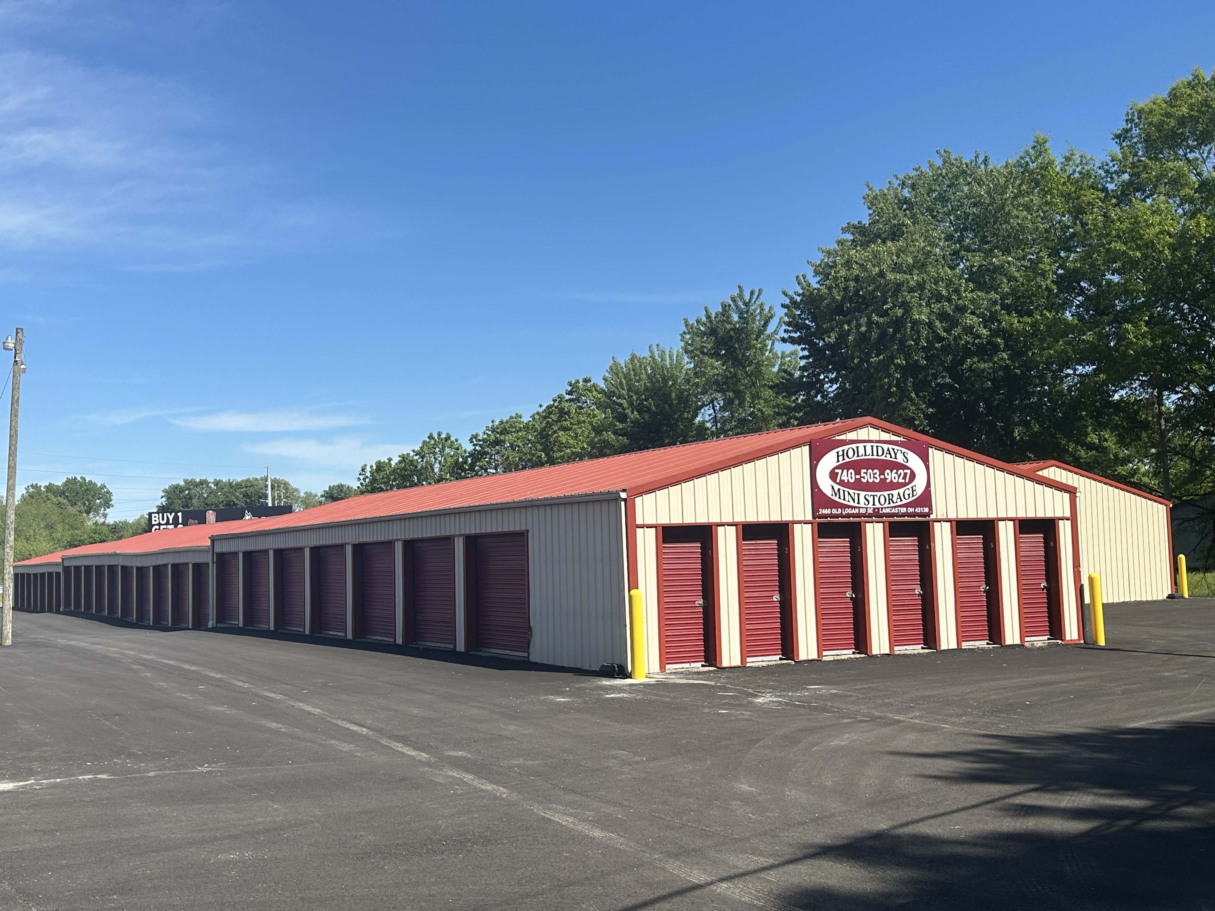 Row of clean burgundy roll-up storage doors with drive-up access at Holliday's Mini Storage in Lancaster Ohio.